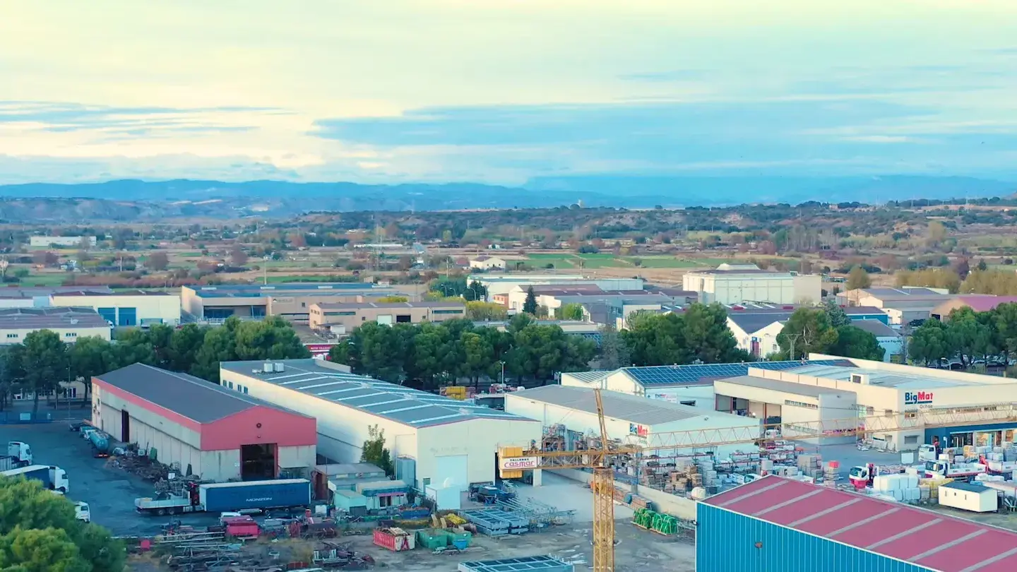 Monzón's industrial estate, warehouses and a crane, farmland beyond